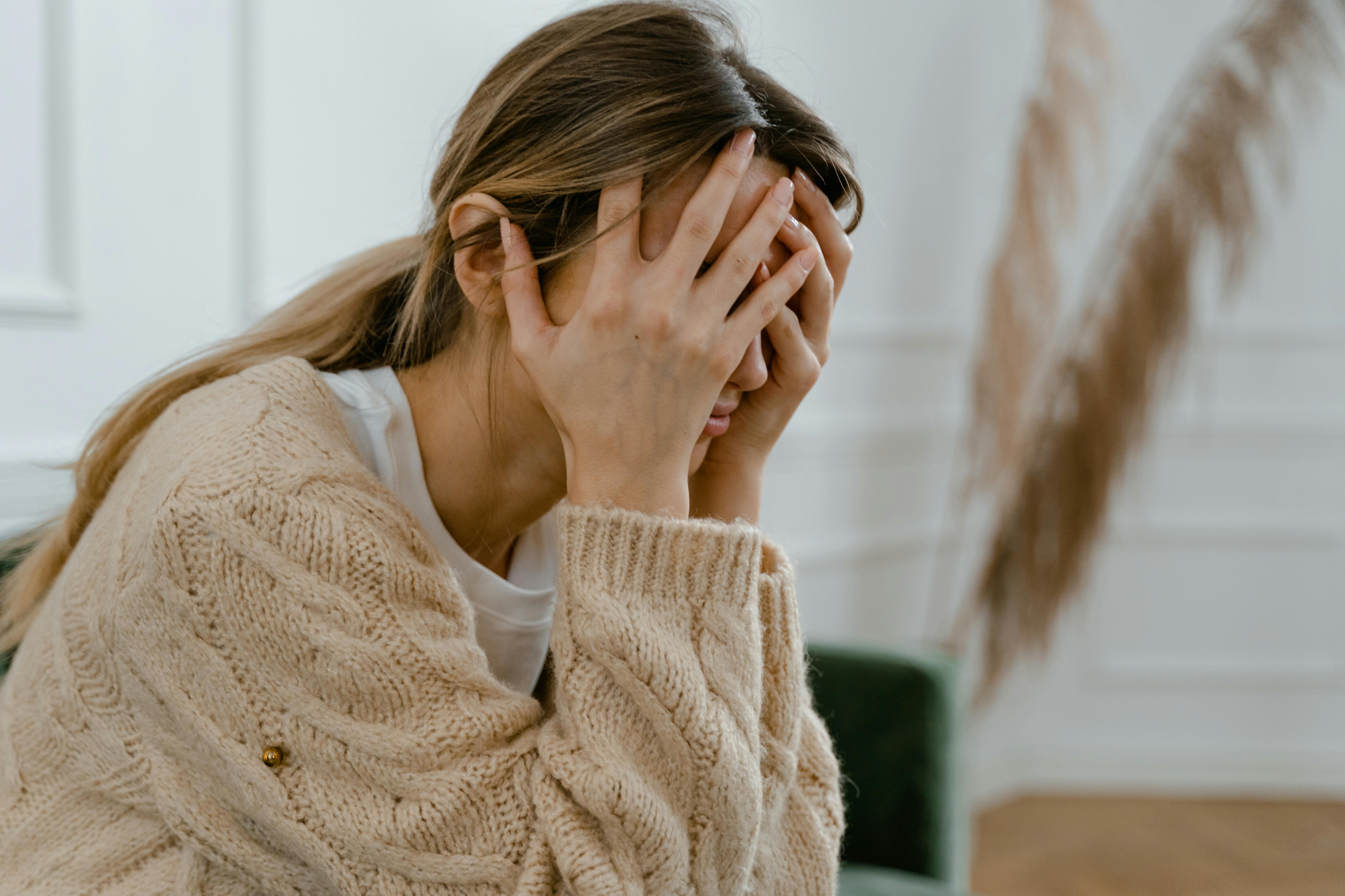 Femme anxieuse, visage dans les mains